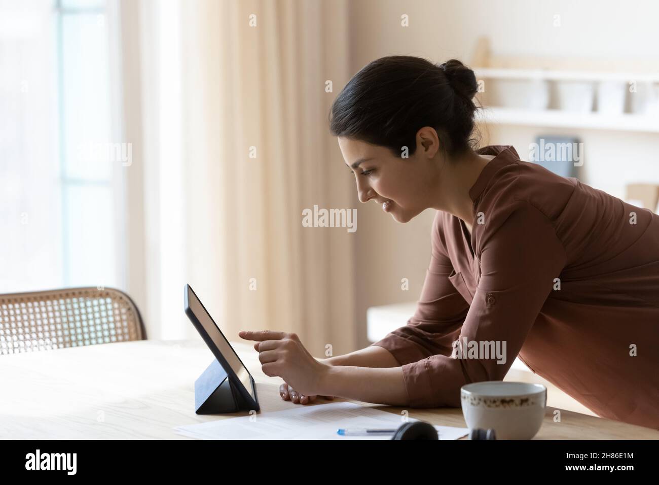 Smiling young indian woman using digital tablet. Stock Photo