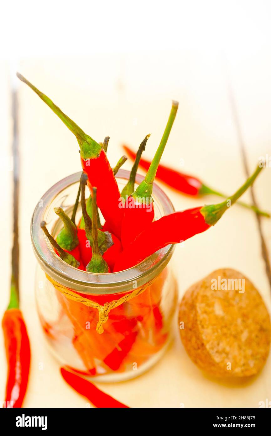 red chili peppers on a glass jar over white wood rustic table Stock ...