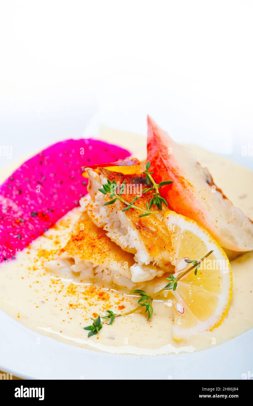 sea bream orata  fillet butter pan fried with fresh peach prune and dragonfruit slices thyme on top Stock Photo