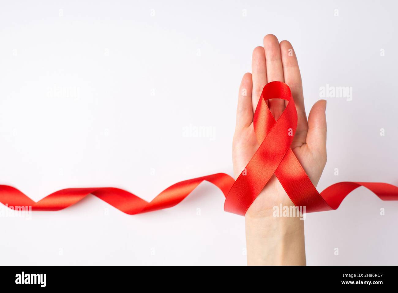 First person top view photo of female hand holding curly red ribbon in ...