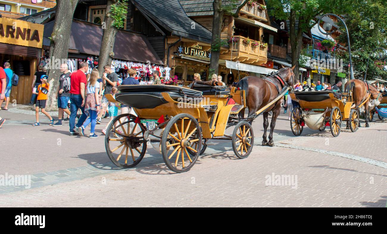 Zakopane, Poland - August 6, 2019 : Horse carriage waiting for the tourists on the Krupowki street in Zakopane in the summer. Harnessed horses. Touris Stock Photo