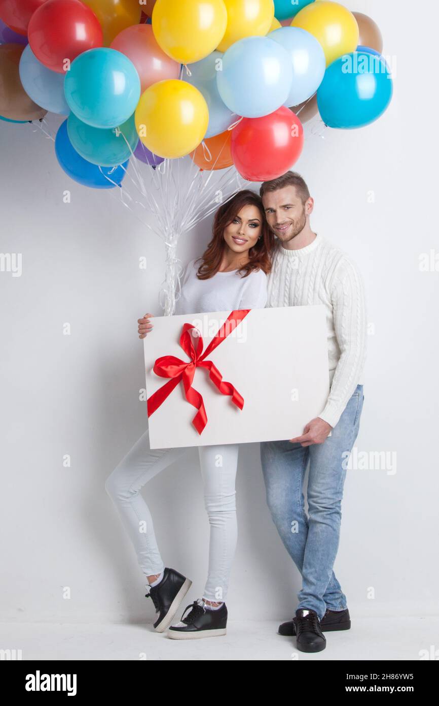 Young smiling couple with balloons and big gift box, Valentine day ...