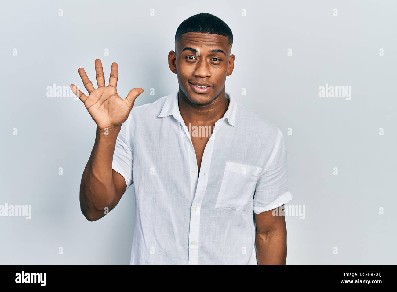 Young black man wearing casual white shirt showing and pointing up with ...