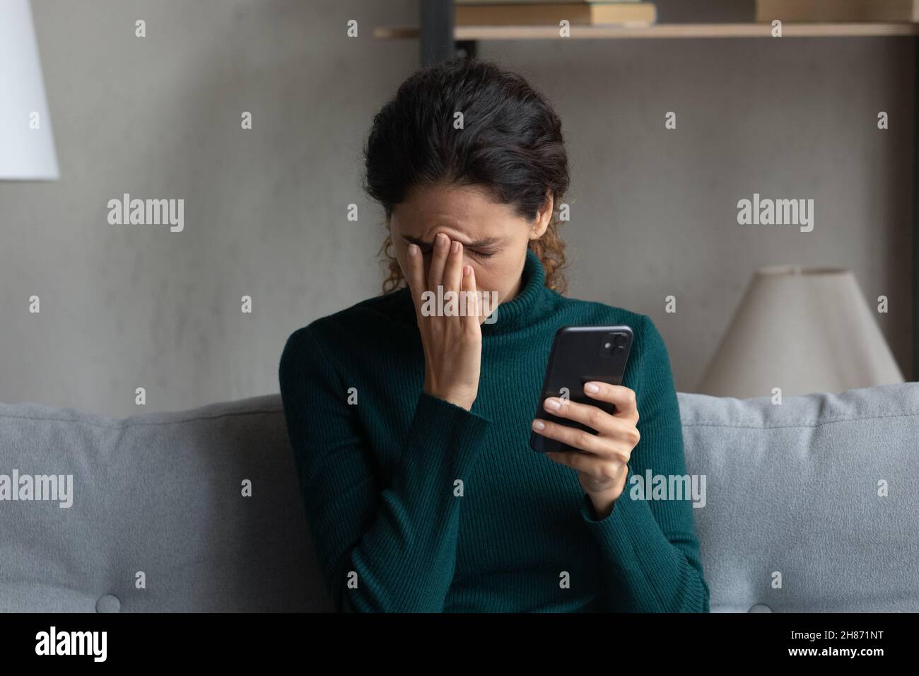 Desperate millennial woman get phone message about dismissal from job Stock Photo