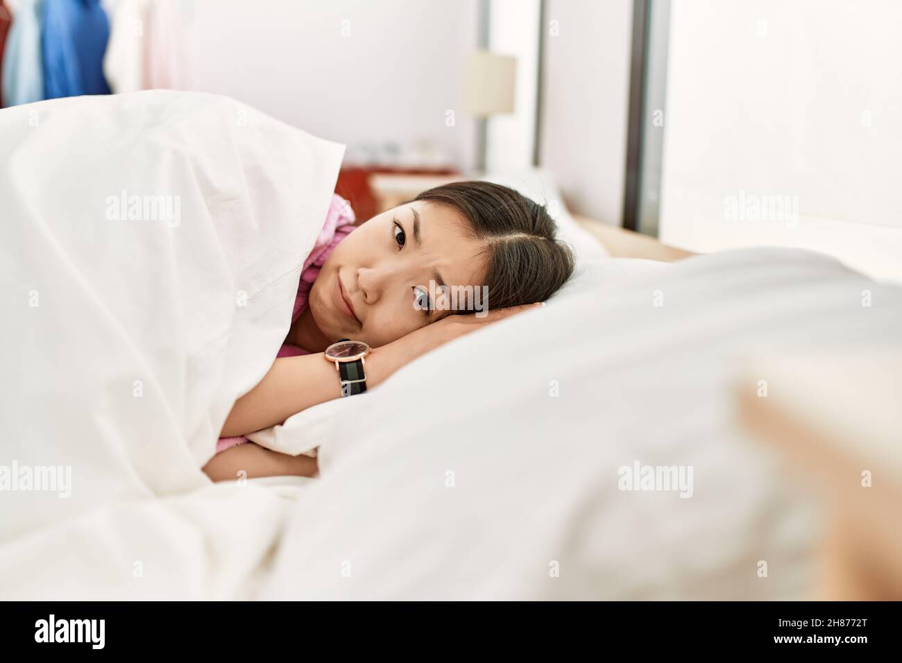 Young chinese girl smiling happy lying on the bed at bedroom Stock ...