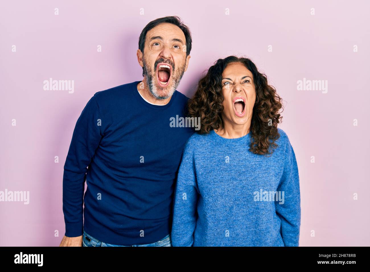 Middle age couple of hispanic woman and man hugging and standing ...