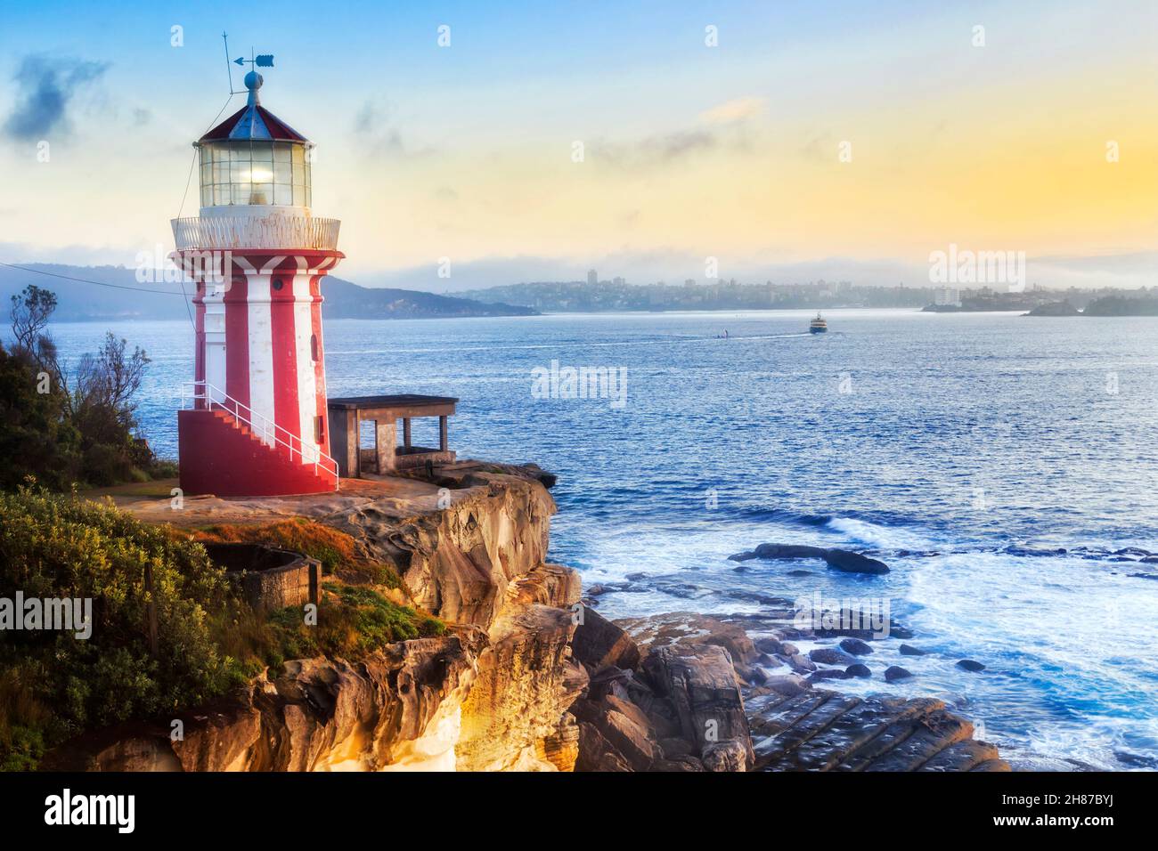 Striped hornby lighthouse on the South Head at the entrance to Sydney Harbour from Pacific ocean at sunrise with illuminated light. Stock Photo