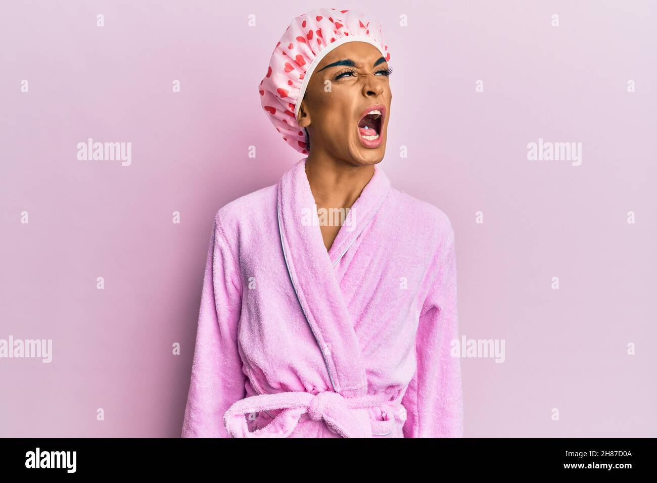 Hispanic man wearing make up wearing shower towel cap and bathrobe ...