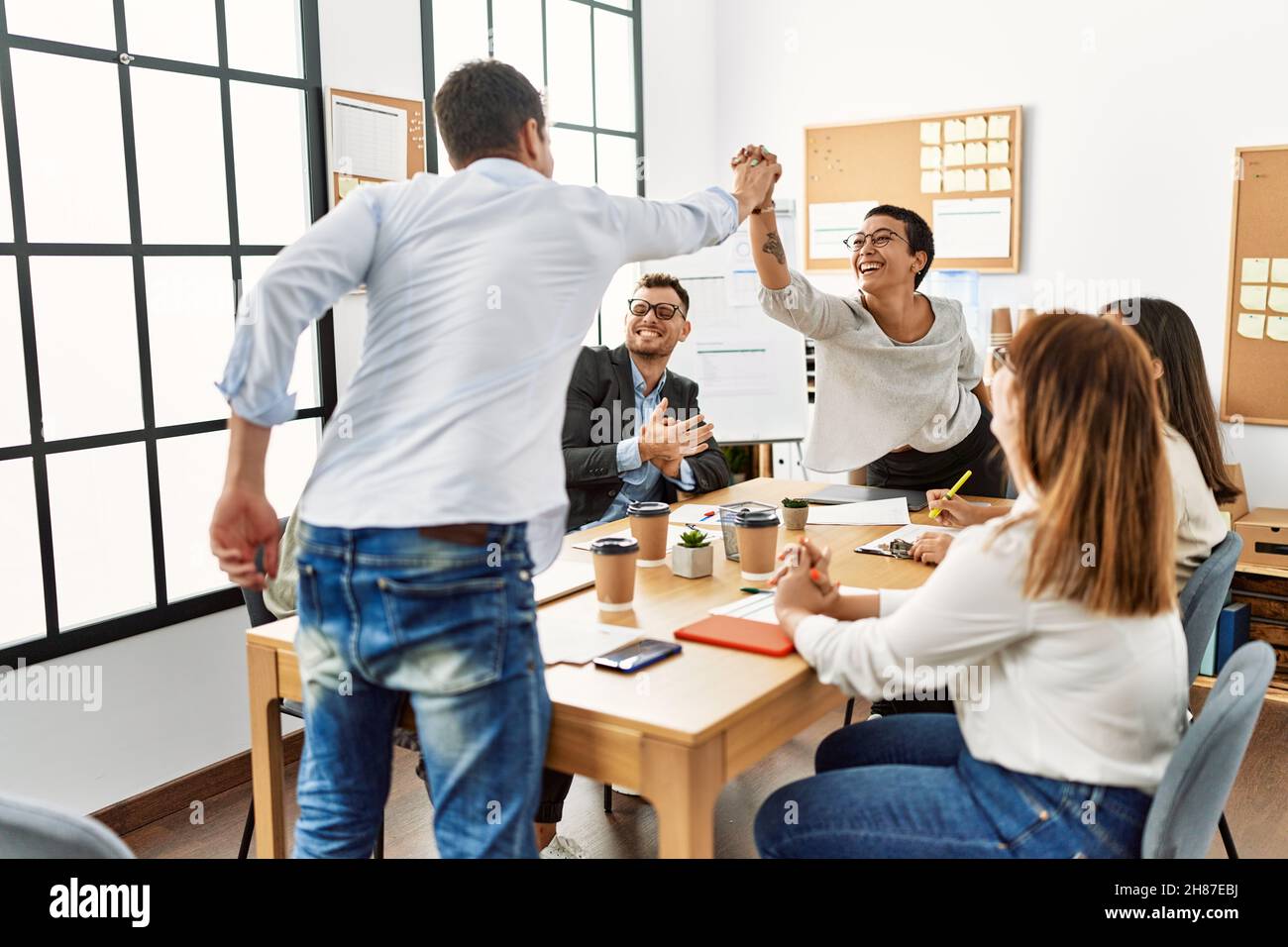 Two workers smiling happy high five during meeting at the office Stock ...