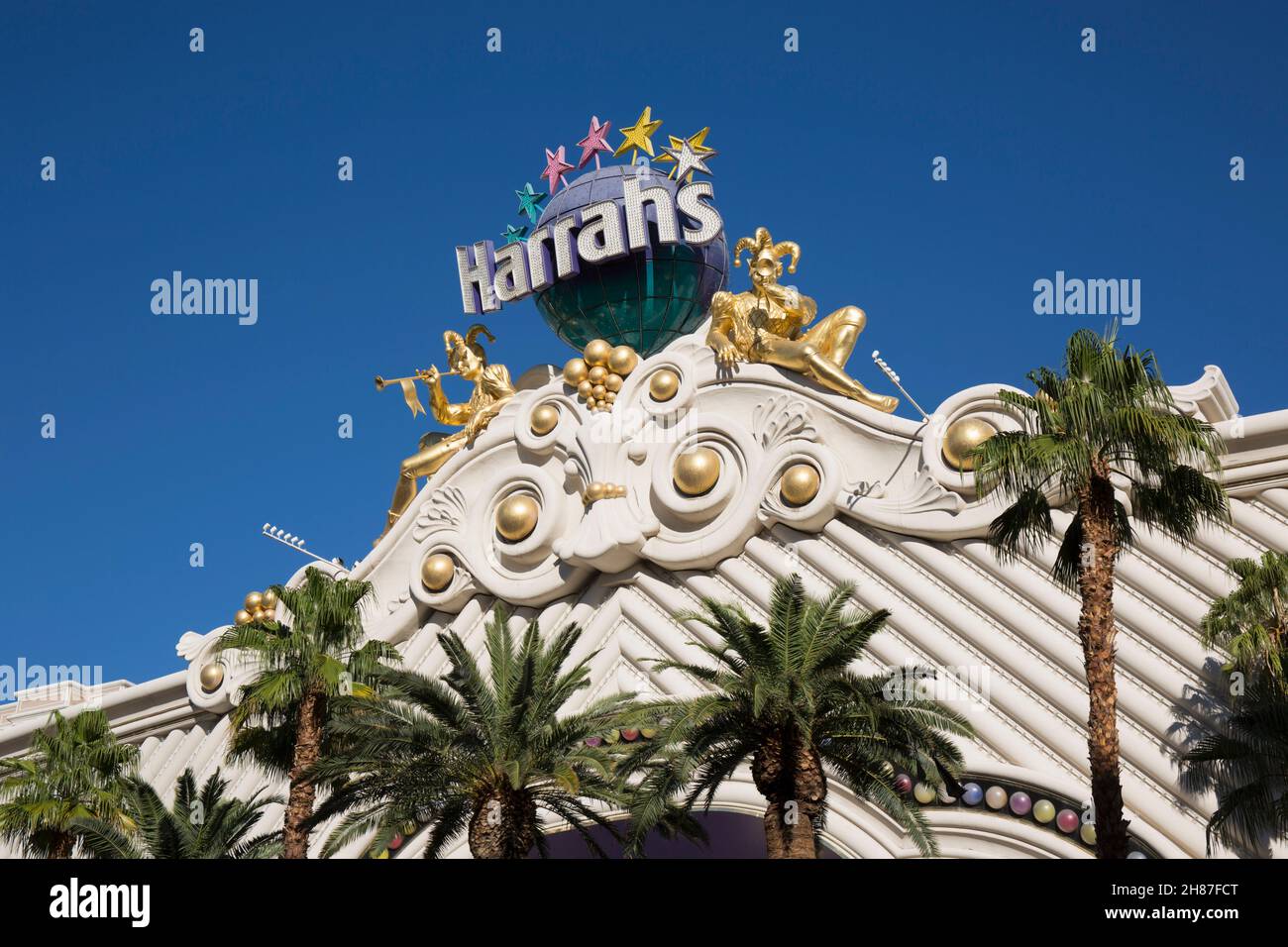 Las Vegas, Nevada, USA. Golden carnival ornamentation adorning the upper façade of Harrah's Las Vegas Hotel and Casino, palm trees in foreground. Stock Photo