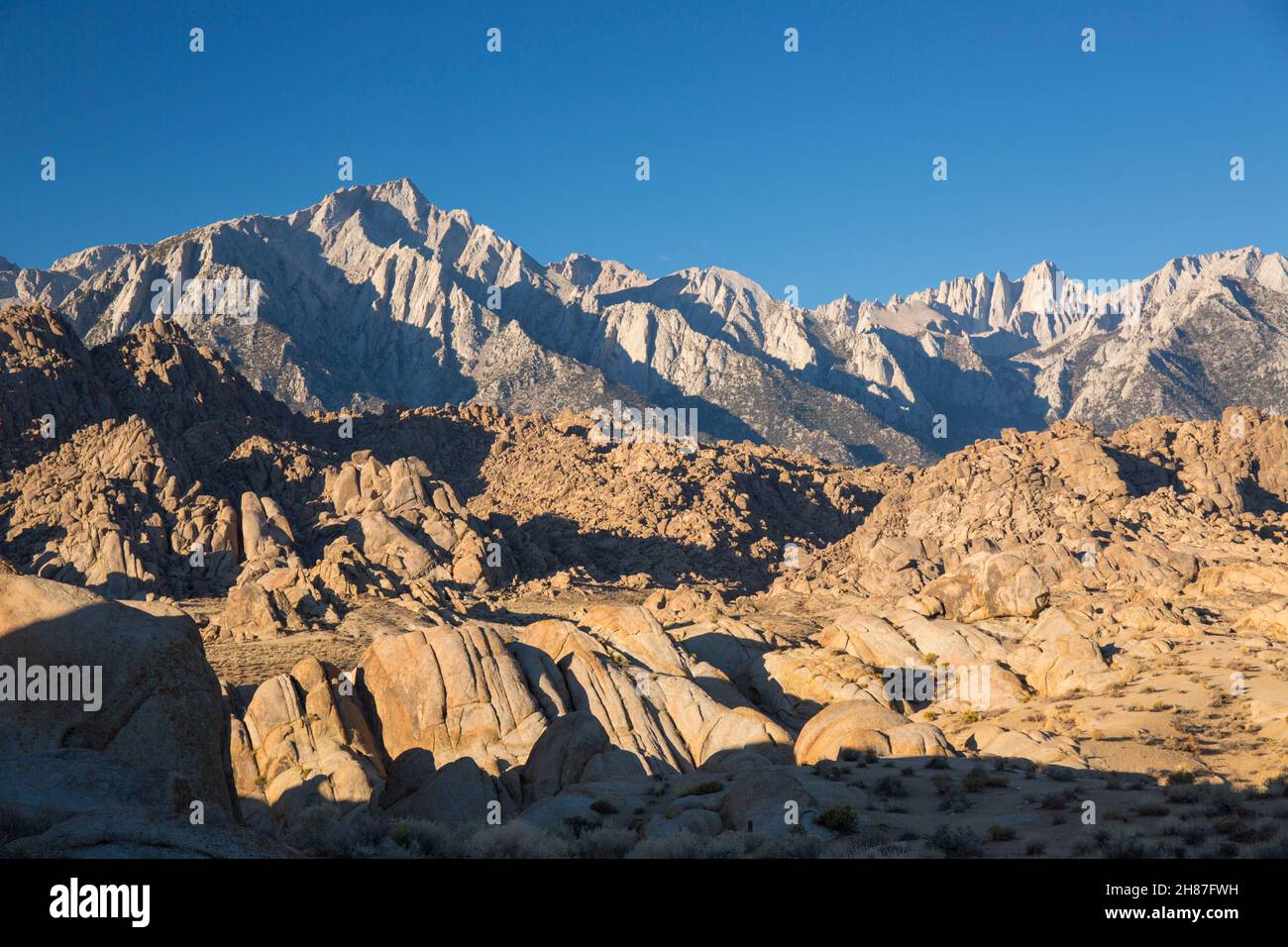 Alabama Hills National Scenic Area, Lone Pine, California, USA. View across rocky desert landscape to Lone Pine Peak and Mount Whitney, sunrise. Stock Photo