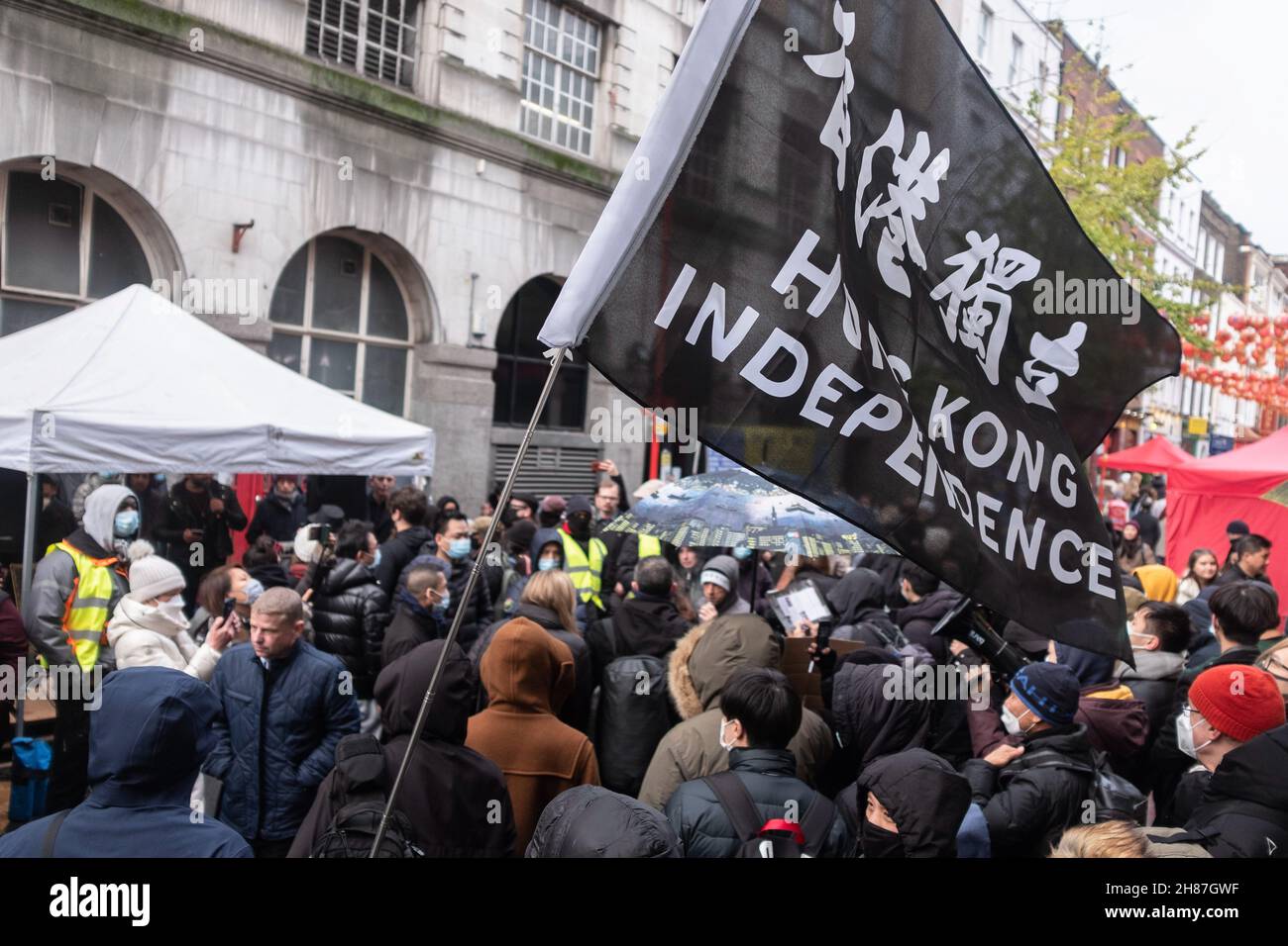 London, UK. 27th Nov, 2021. A protester holds a flag in the middle of the crowd during the rally.'Anti-Asian Hate' rally organized by Pro-Beijing protesters and 'Lunch with you' rally organized by Hong Kong democracy protesters, separately gather at the same spot in Chinatown in London. While Pro-Beijing group shouting No Anti-Asian Hate, Hongkongers came back with Resist Chinese Communist Party (CCP) and No to Genocide. Credit: SOPA Images Limited/Alamy Live News Stock Photo