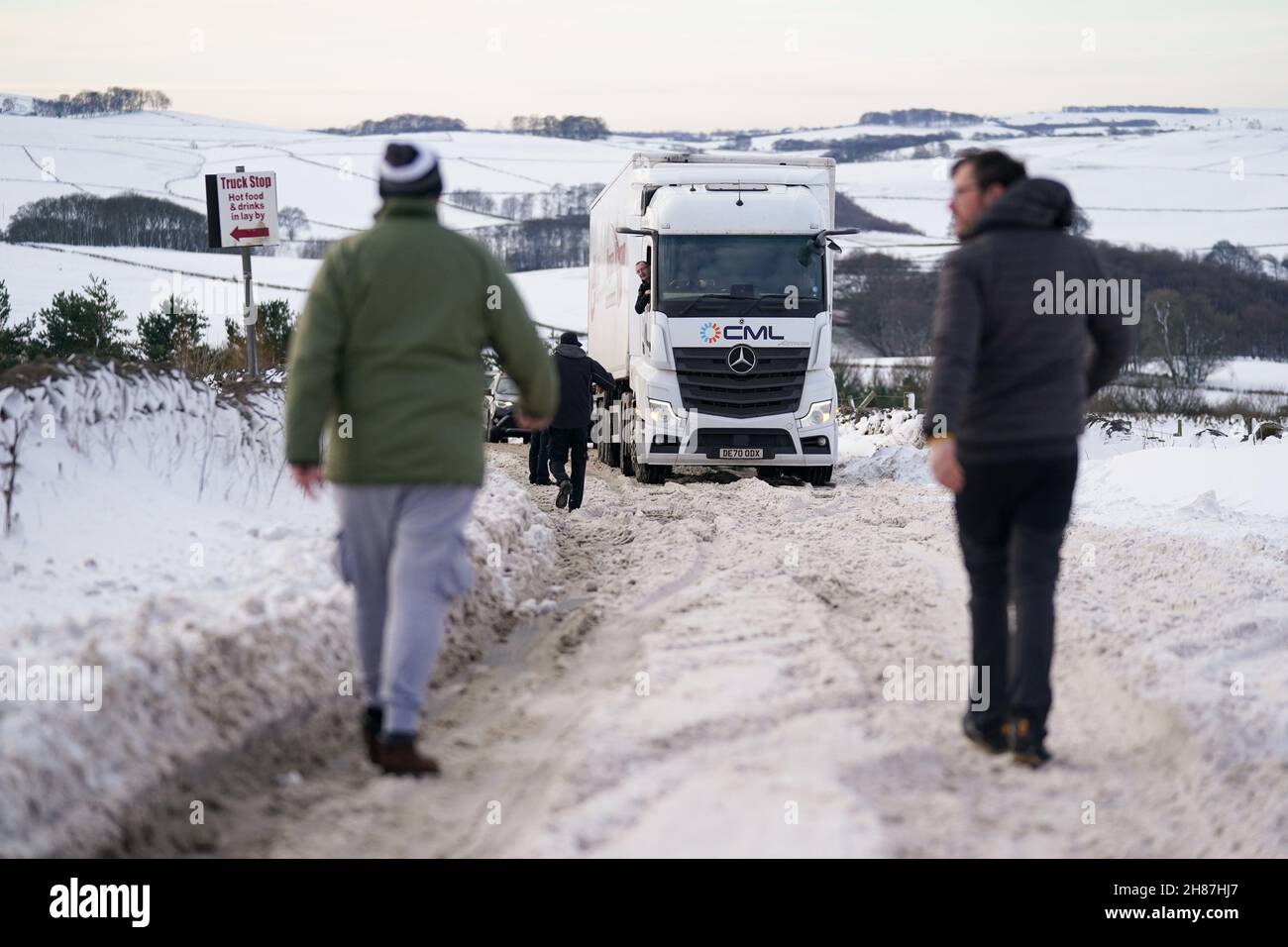 Motorists gather by a stuck HGV along the snow-covered A515 near Biggin, in the Peak District, Derbyshire, amid freezing conditions in the aftermath of Storm Arwen. Picture date: Sunday November 28, 2021. Stock Photo