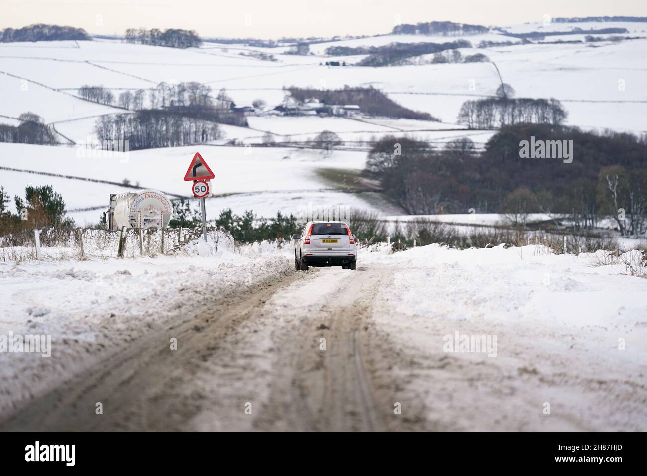Vehicles attempt to travel along the snow-covered A515 near Biggin, in the Peak District, Derbyshire, amid freezing conditions in the aftermath of Storm Arwen. Picture date: Sunday November 28, 2021. Stock Photo
