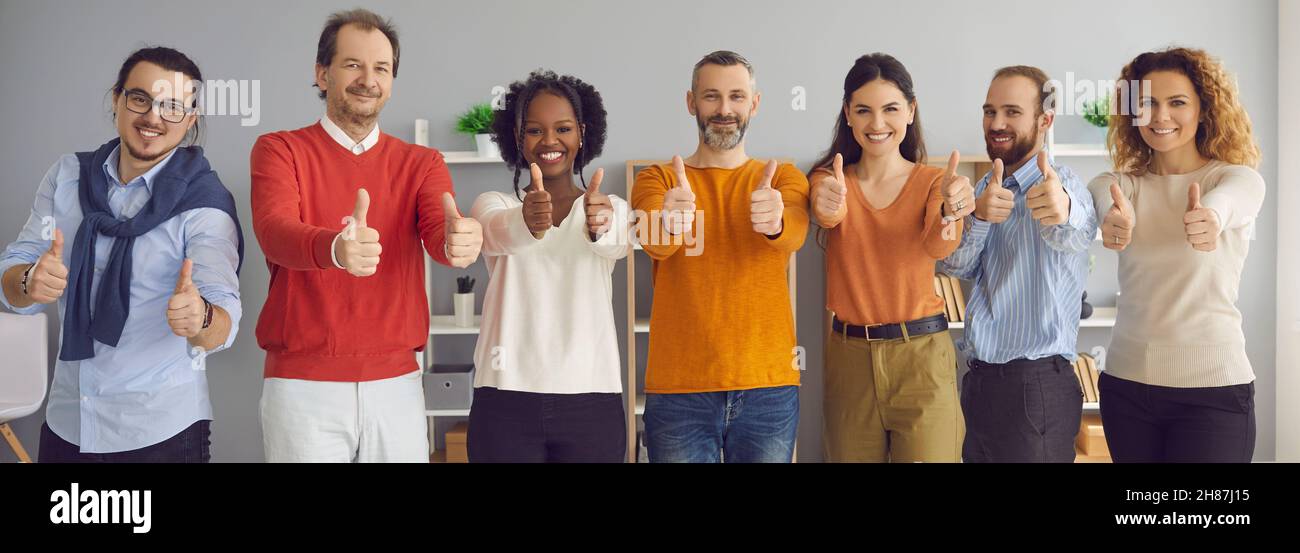 Happy smiling business people group showing thumbs up together to camera Stock Photo