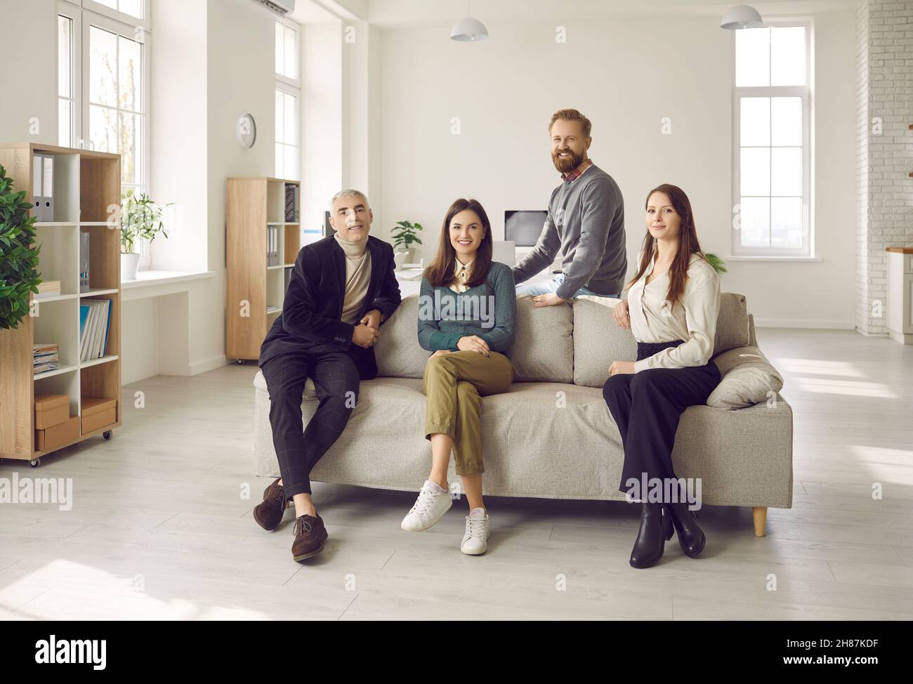 Diverse employees pose together in office Stock Photo