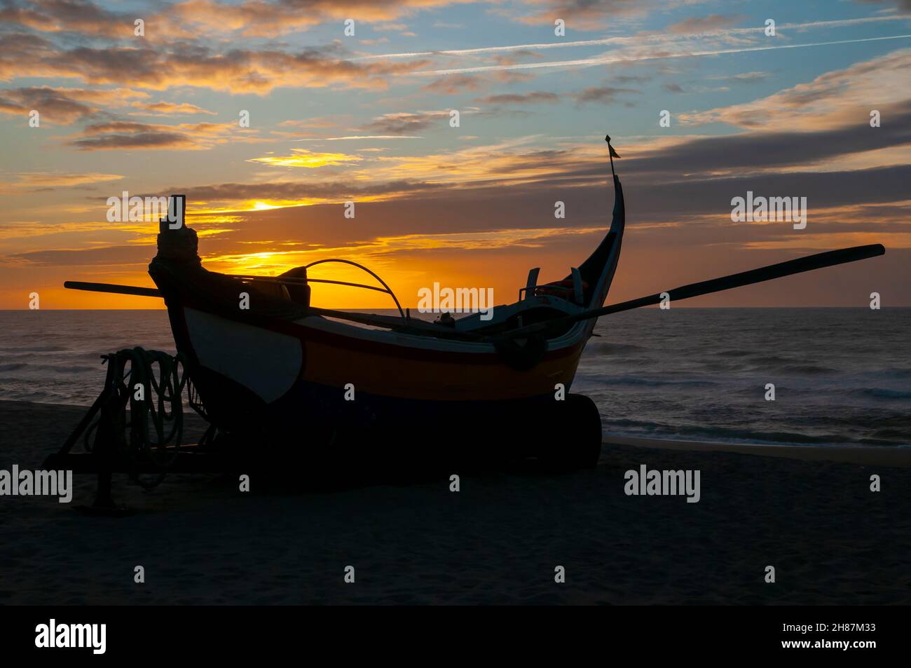 Silhouette of traditional colorful Portuguese fishing boat on the beach at Vieira de Leiria. A Portuguese village and also a parish in the municipalit Stock Photo