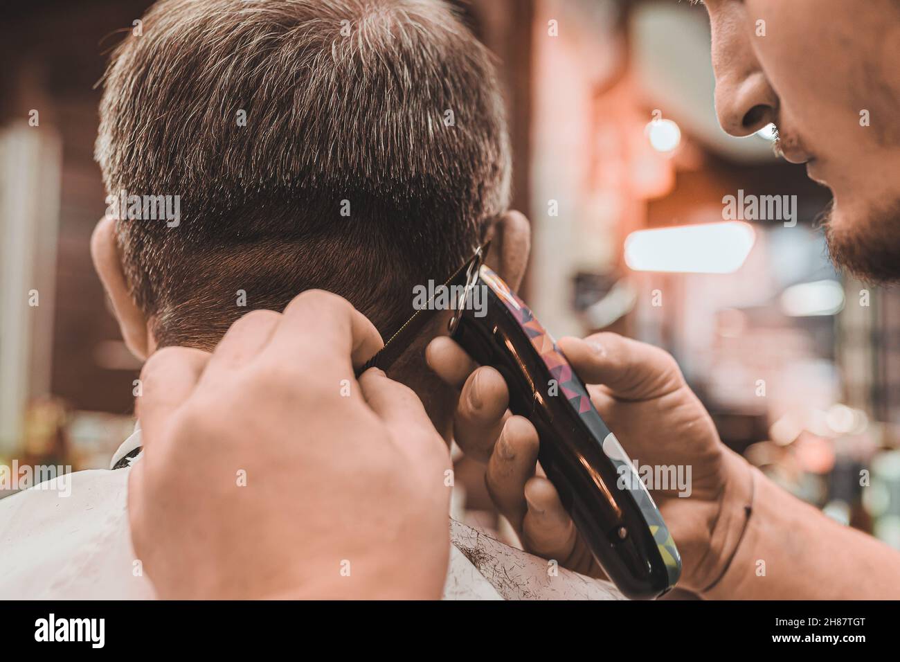 Barbershop. hairdresser professionally performs a haircut for men. man client sits in professional barber chair, and hairdresser makes haircut. Stock Photo