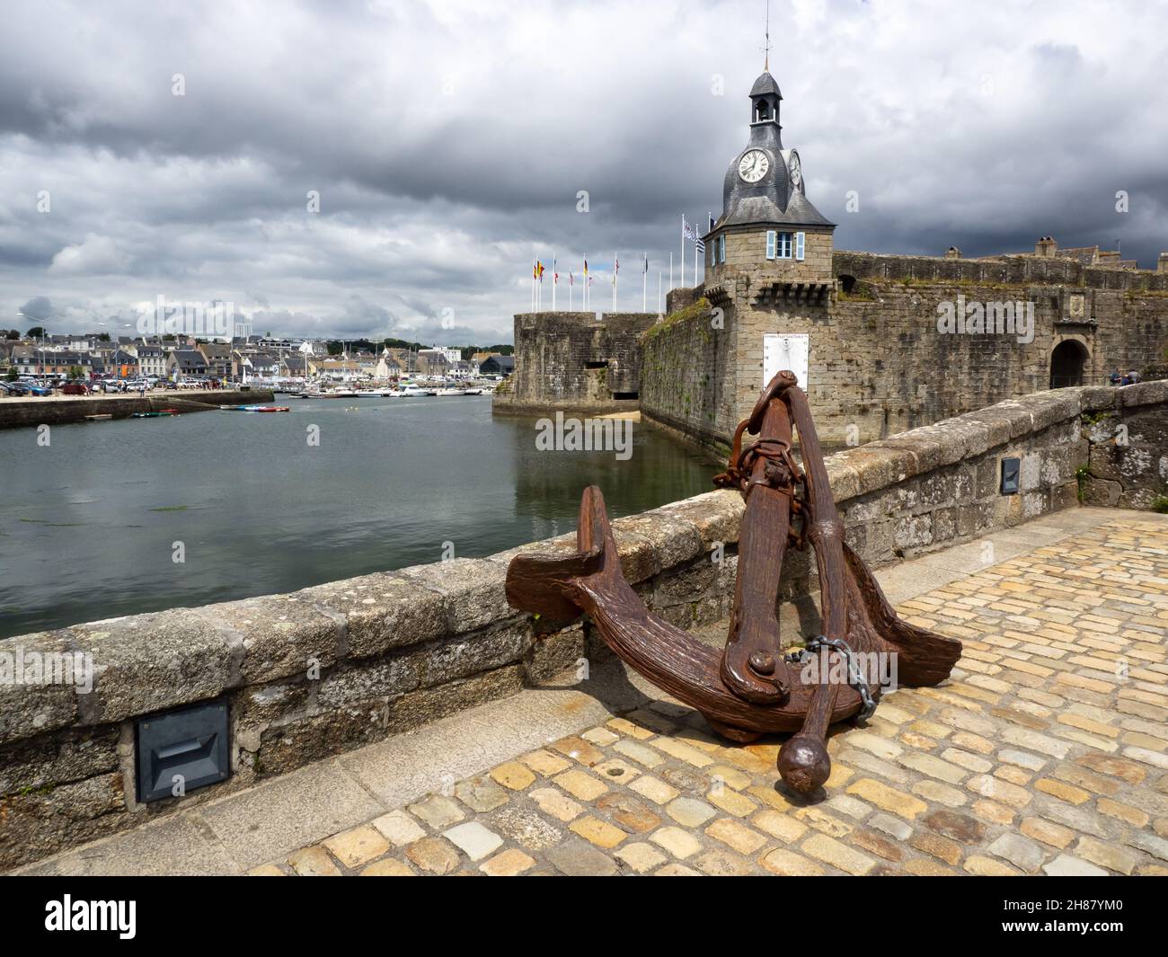 View on an old anchor with the fortress of Concarneau in background Stock Photo