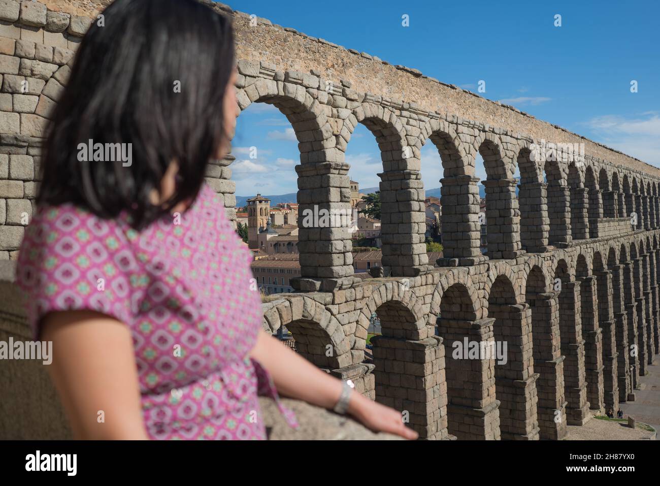 woman at Segovia acueducto viewpoint during vacation in Spain - young happy woman visiting world heritage aqueduct in Segovia enjoying holidays travel Stock Photo