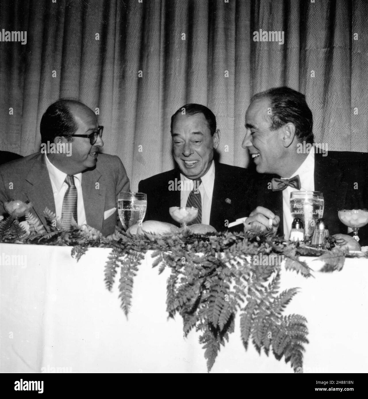 HUMPHREY BOGART candid photo with comedians PHIL SILVERS and JOE E. LEWIS during his afternoon NEW YORK FRIARS CLUB ROAST in September 1955 Stock Photo