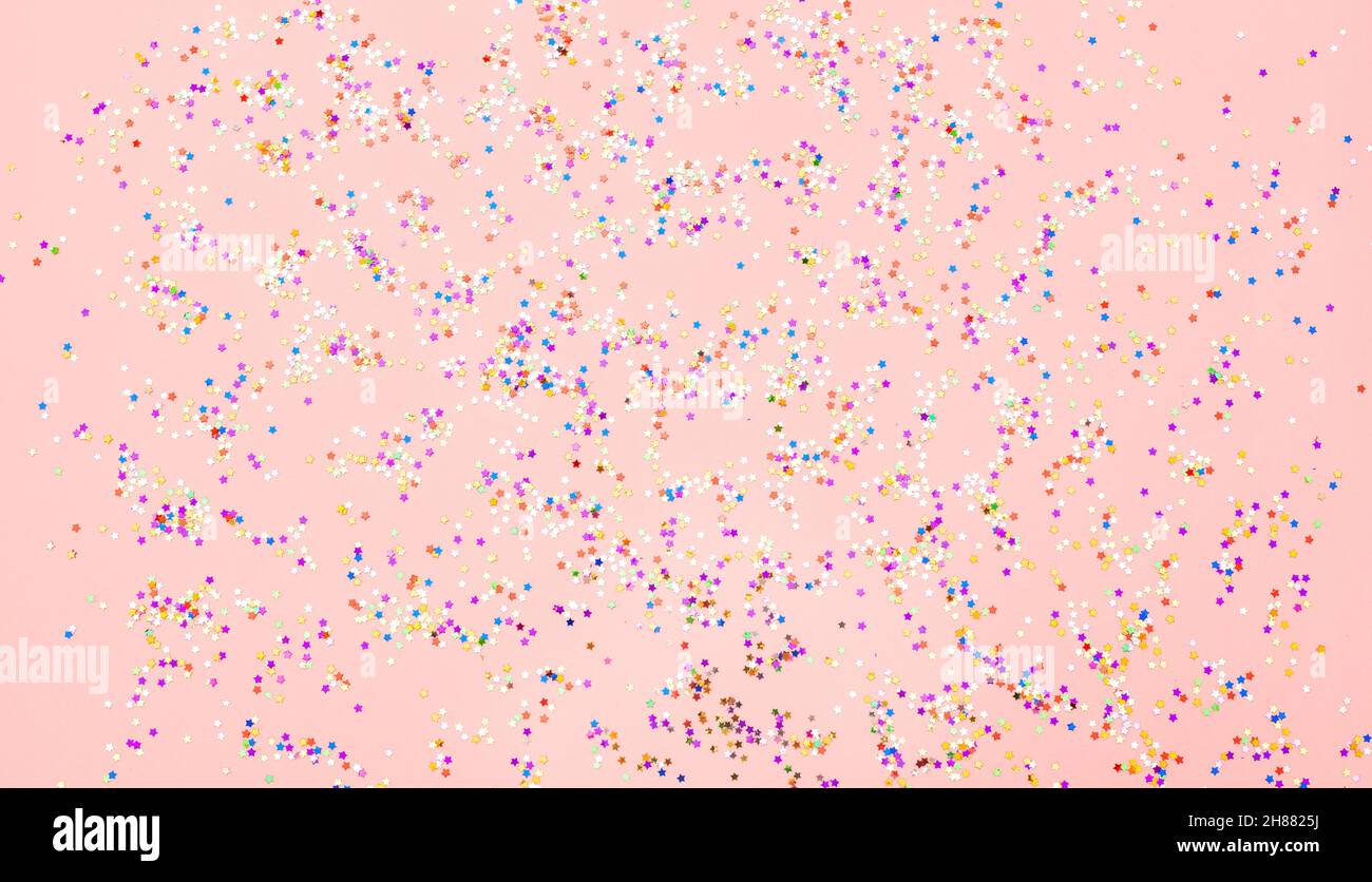Multicolored confetti glitter on pink background Stock Photo