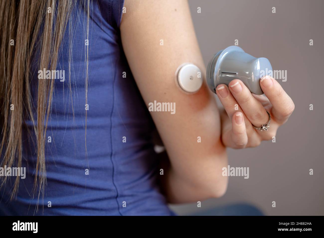 Closeup of girl applying flash glucose monitoring patch on her arm