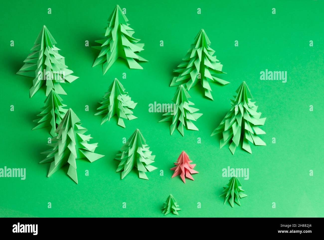 Several paper Christmas trees made using the origami technique on green ...