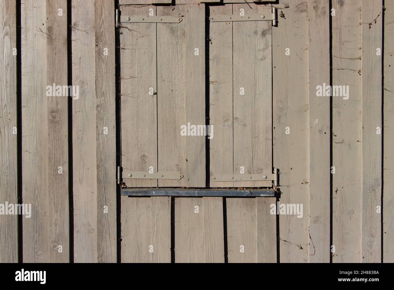 Wooden window shutter on a gray wooden plank wall Stock Photo
