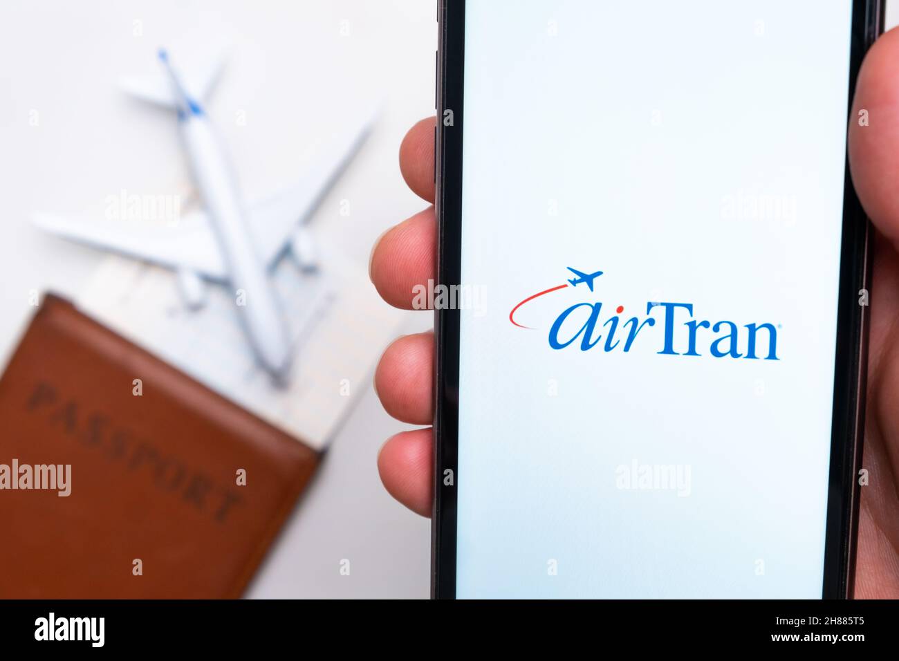 AirTran Airline app on a smartphone screen with a plane and passport on the background. The concept of travel app. November 2021, San Francisco, USA Stock Photo