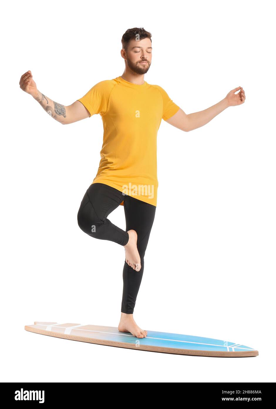 Handsome bearded man with surfboard meditating on white background Stock Photo