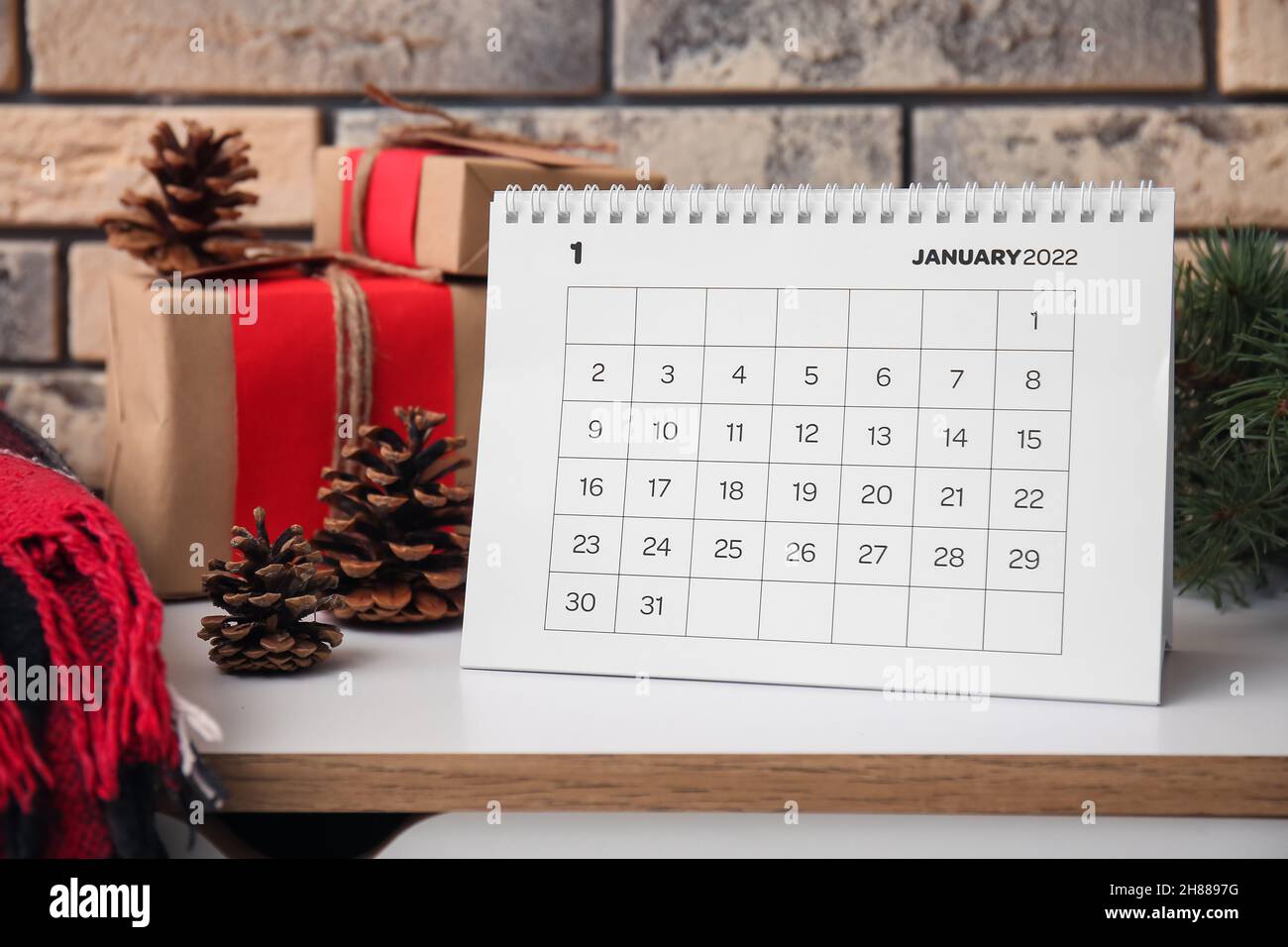 Paper calendar for January 2022 and Christmas decor on chest of drawers