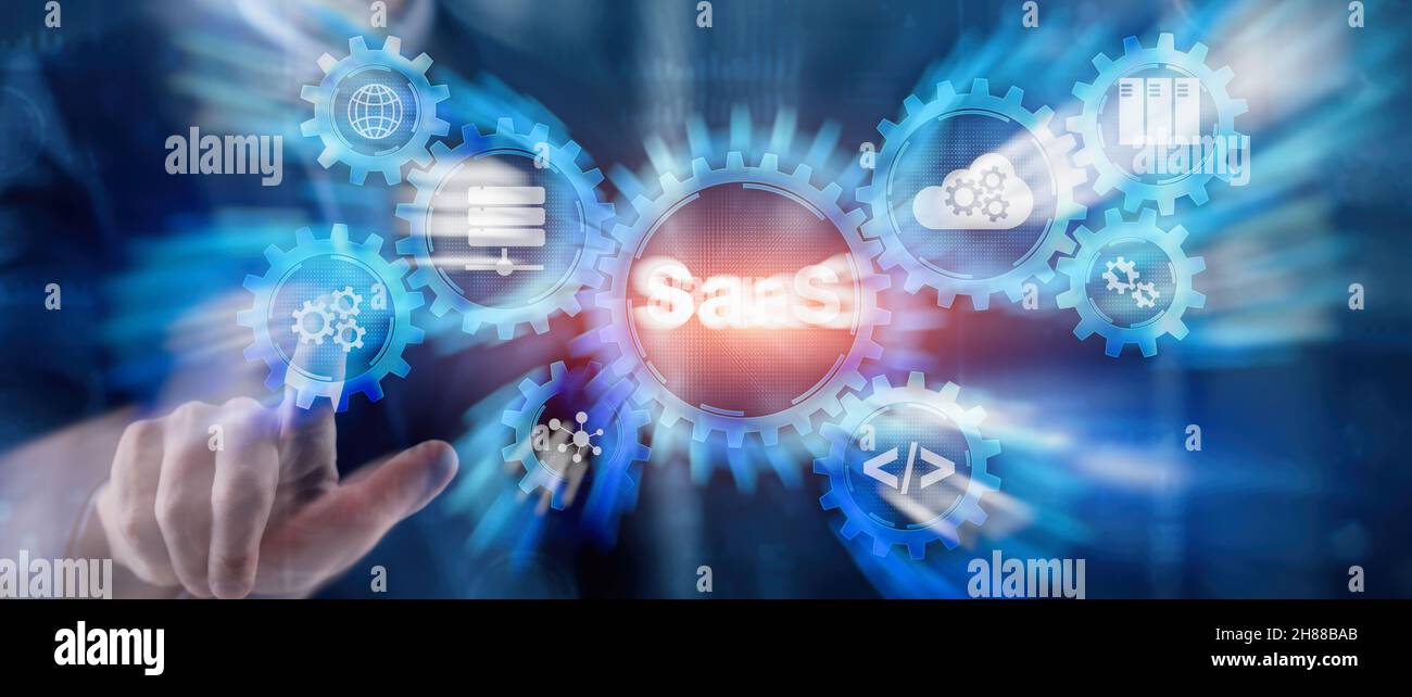 SaaS Software as a Service concept with hand pressing text. Stock Photo