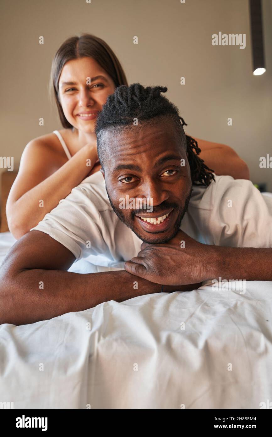 Joyous young couple posing for camera in bed Stock Photo