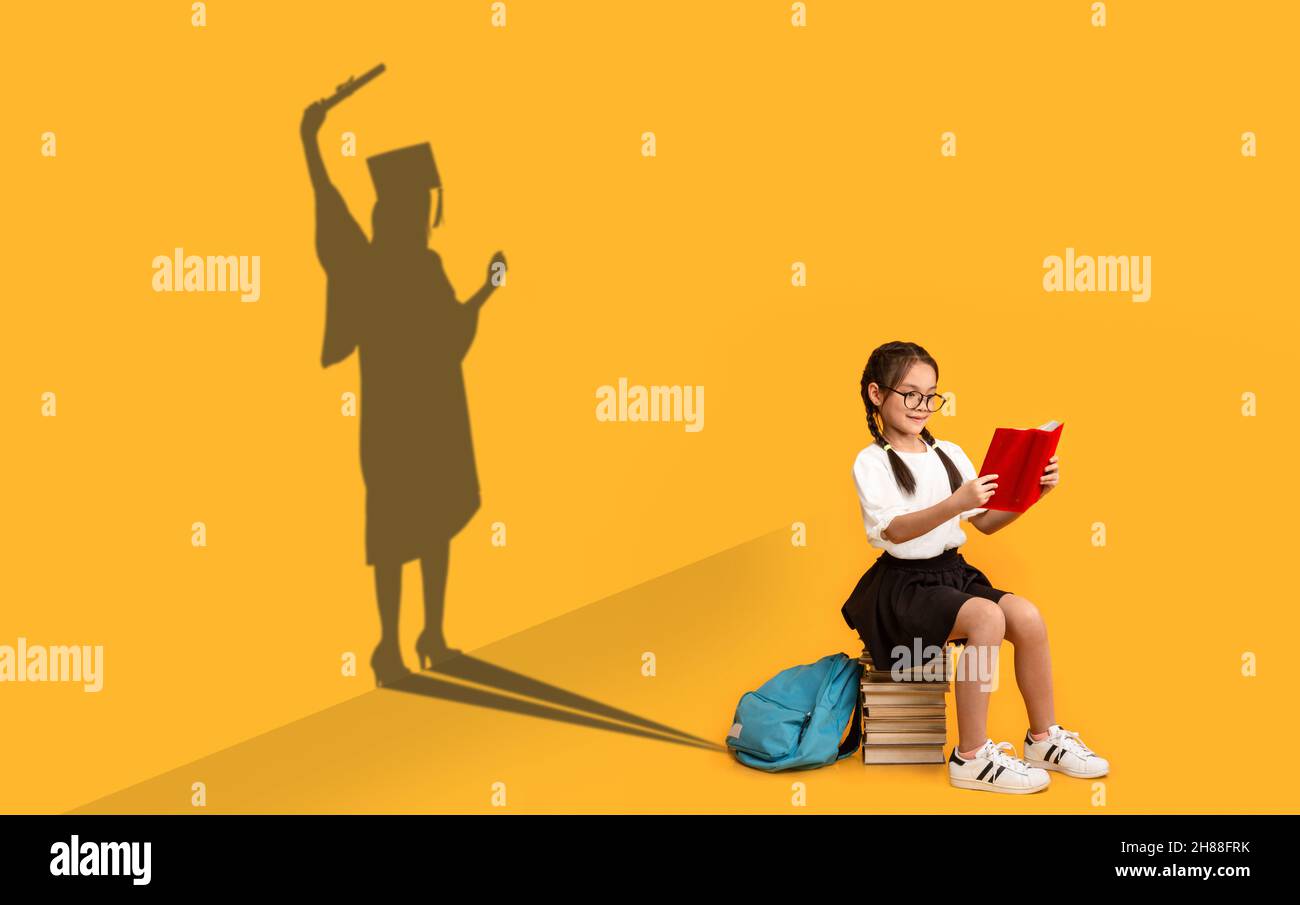 Cheerful Asian Schoolgirl Reading Book, Dreaming About Master Degree Stock Photo
