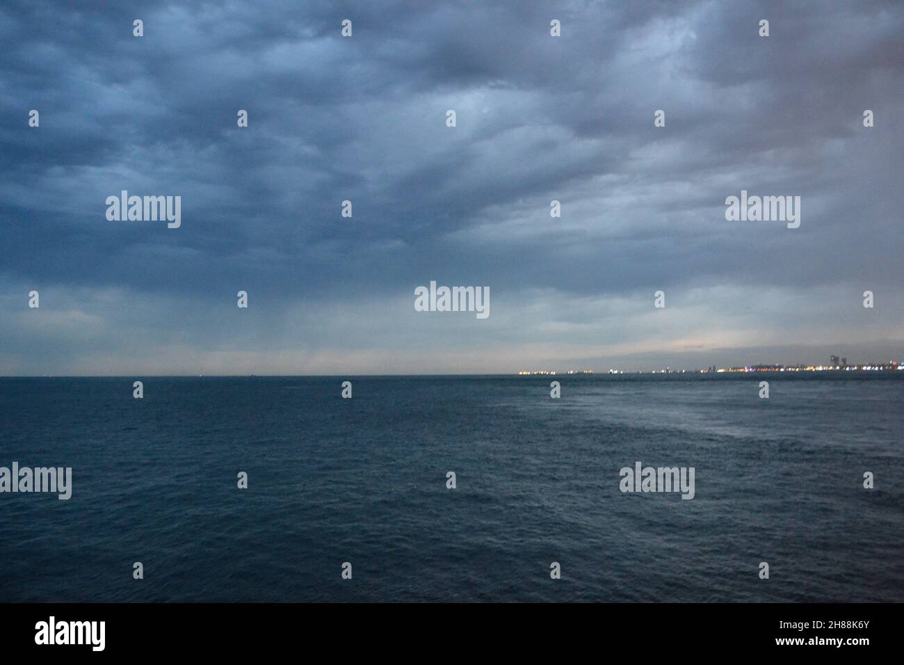 Grey heavy clouds over calm Bosphorus with horizon. Stock Photo