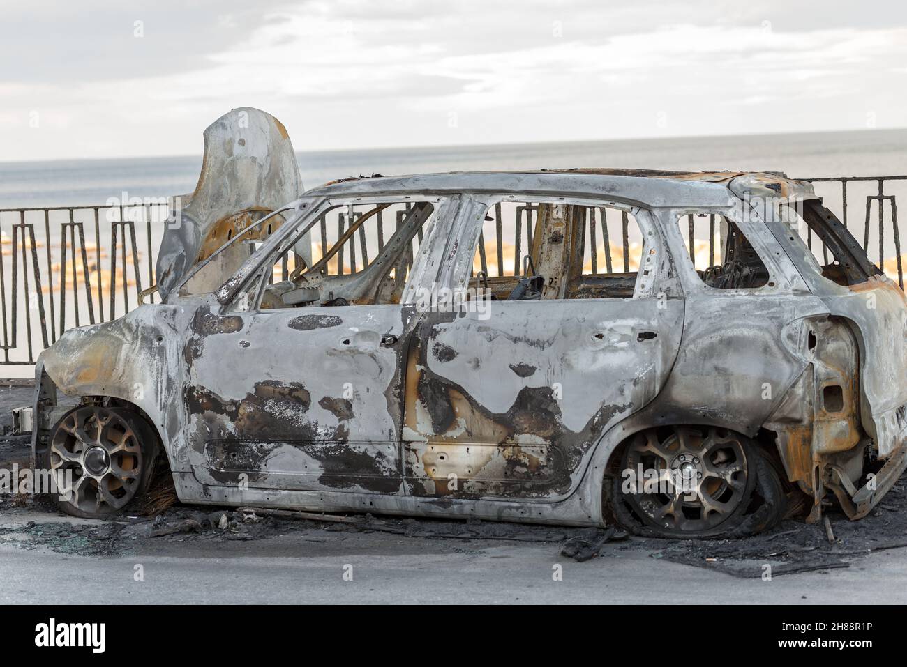 Close-up of a small car burned and abandoned along the road in the small island of Ortigia, Syracuse, Sicily island, Italy, Europe Stock Photo