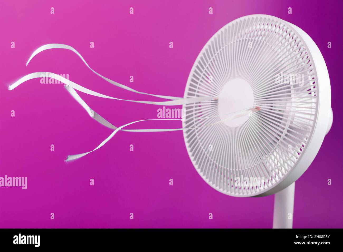The electric fan is white with pink ribbons fluttering in the wind on a pink background. Free