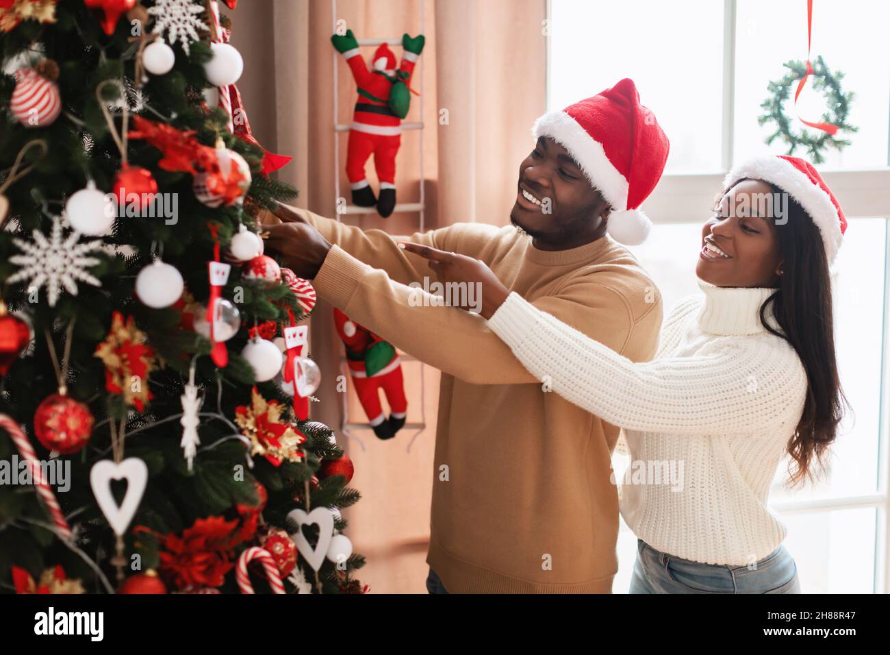 Portrait of happy black family decorating Xmas tree Stock Photo