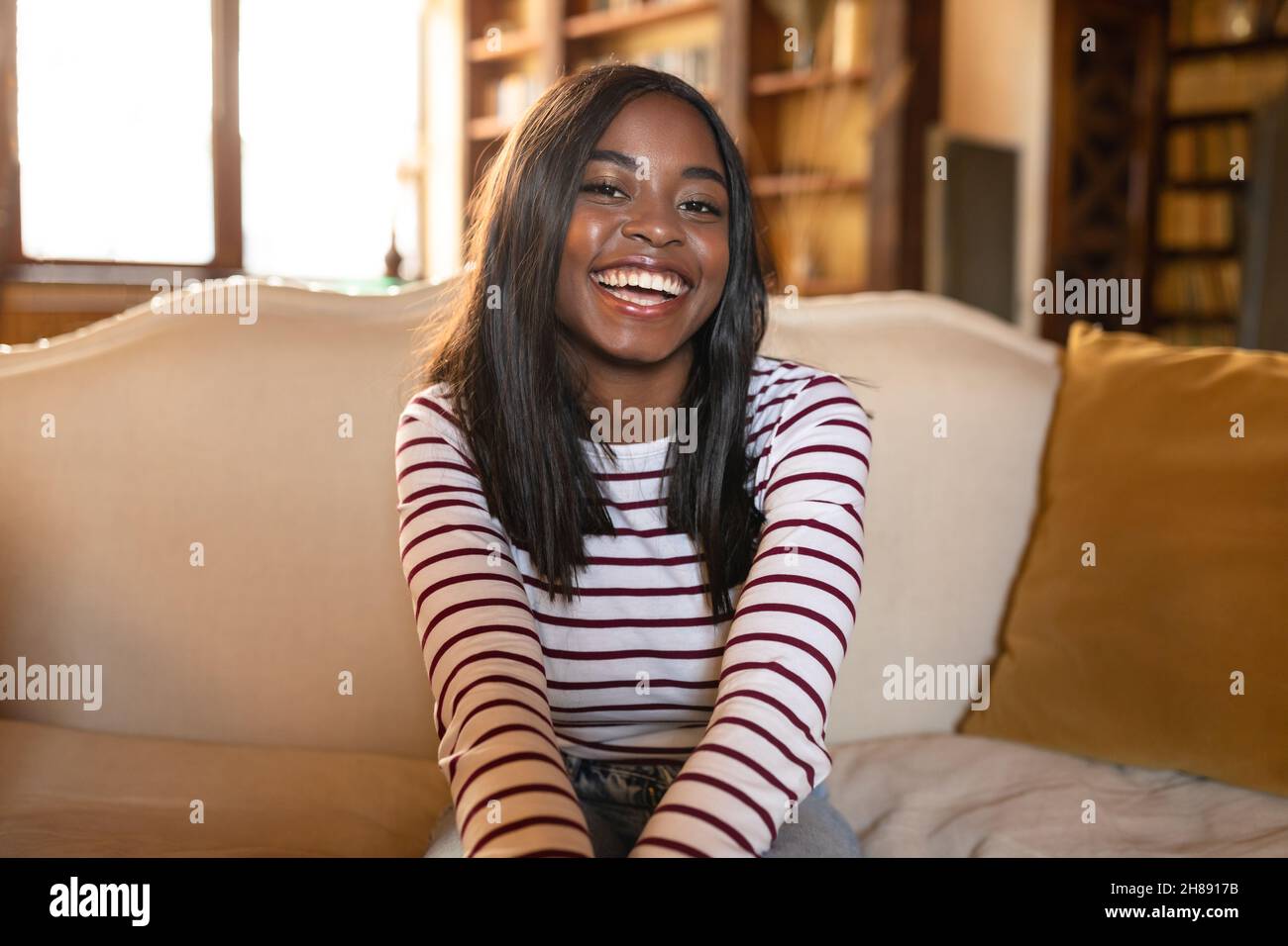 Portrait of happy young African American woman smiling at camera ...