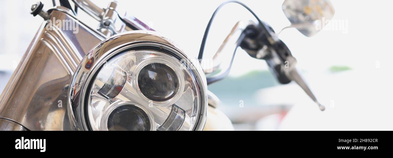Round motorcycle headlight with handlebars and mirrors closeup Stock Photo
