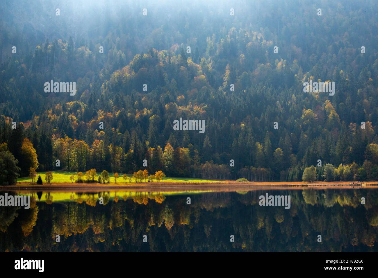 Lake Weitsee in autumn season in backlit with fantastic sunrays light, Reit im Winkl, Chiemgau region, Upper Bavaria, Southern Germany, Stock Photo