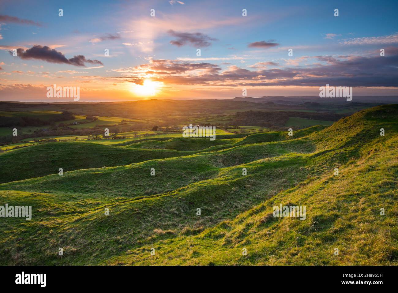 Askerswell, Dorset, UK.  28th November 2021.  UK Weather.  The sunset viewed from the Iron Age hill fort on Eggardon Hill near Askerswell in Dorset.  Picture Credit: Graham Hunt/Alamy Live News Stock Photo