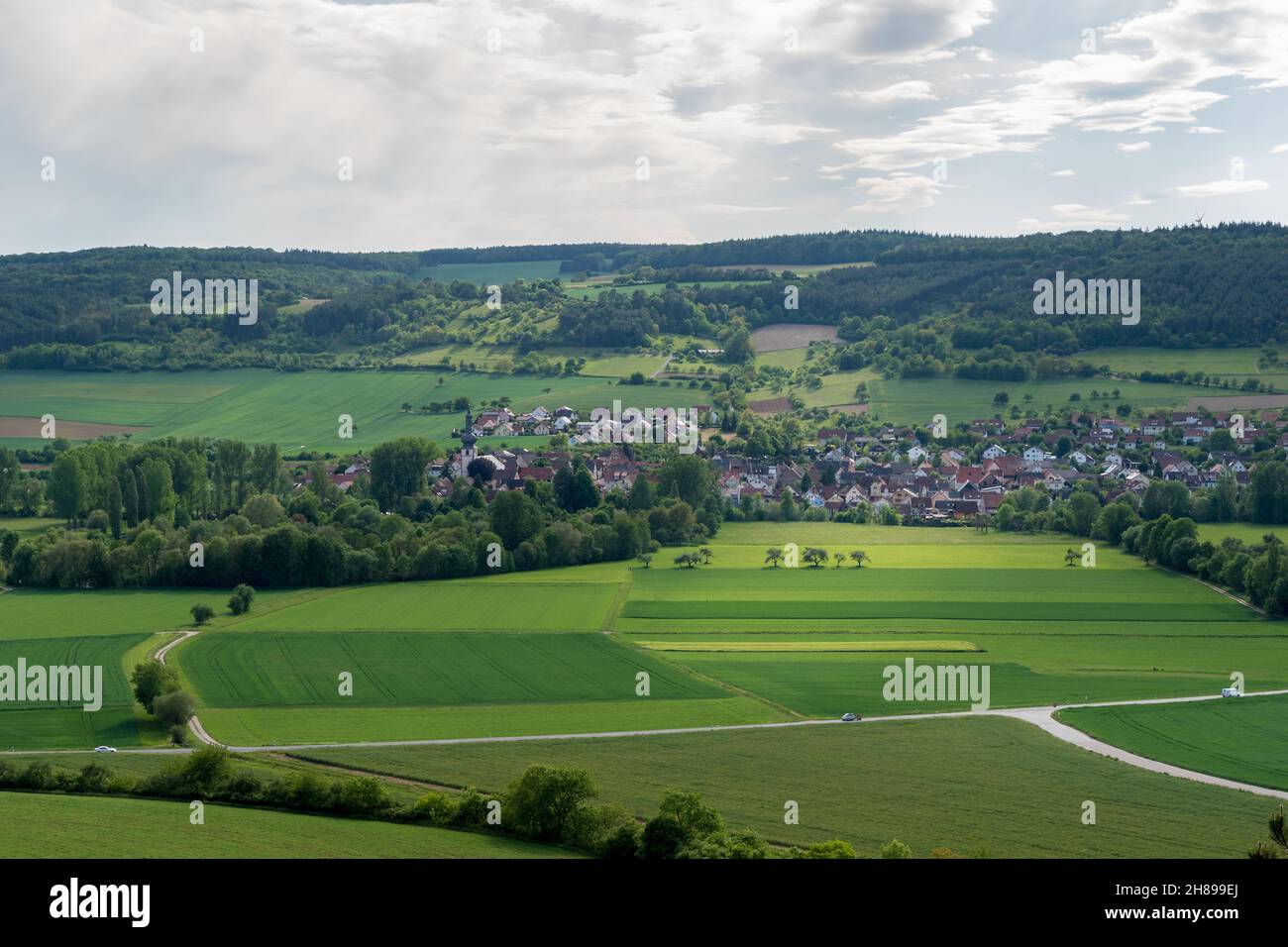 View from an hill to the small village of Hochhausen with a church and the river Tauber in the Taubertal, Baden-Württemberg. Stock Photo