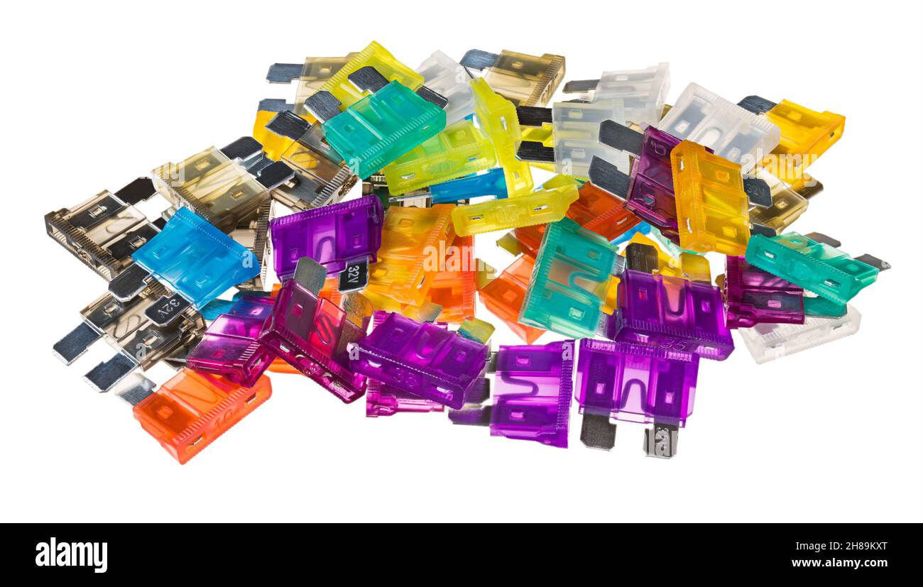 Pile of electric automotive car fuses isolated on white background. Closeup of color coded blade type overcurrent protectors. Current protection parts. Stock Photo