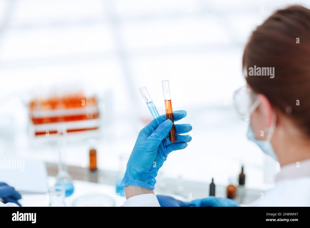 rear view . test tube in hands of the laboratory employee. Stock Photo