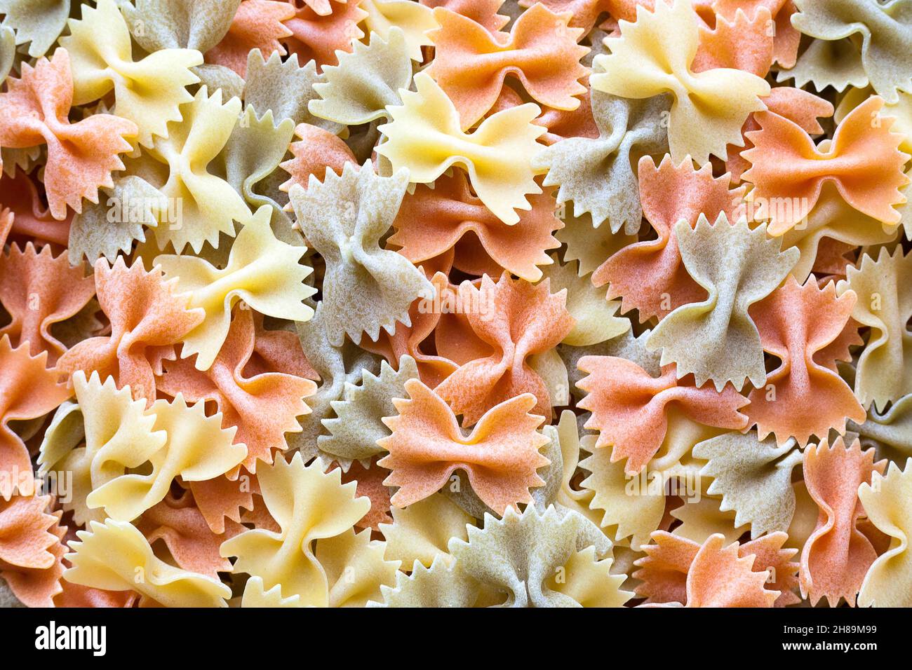 Close-up on a stack of colorful uncooked farfalle from Italy. Stock Photo