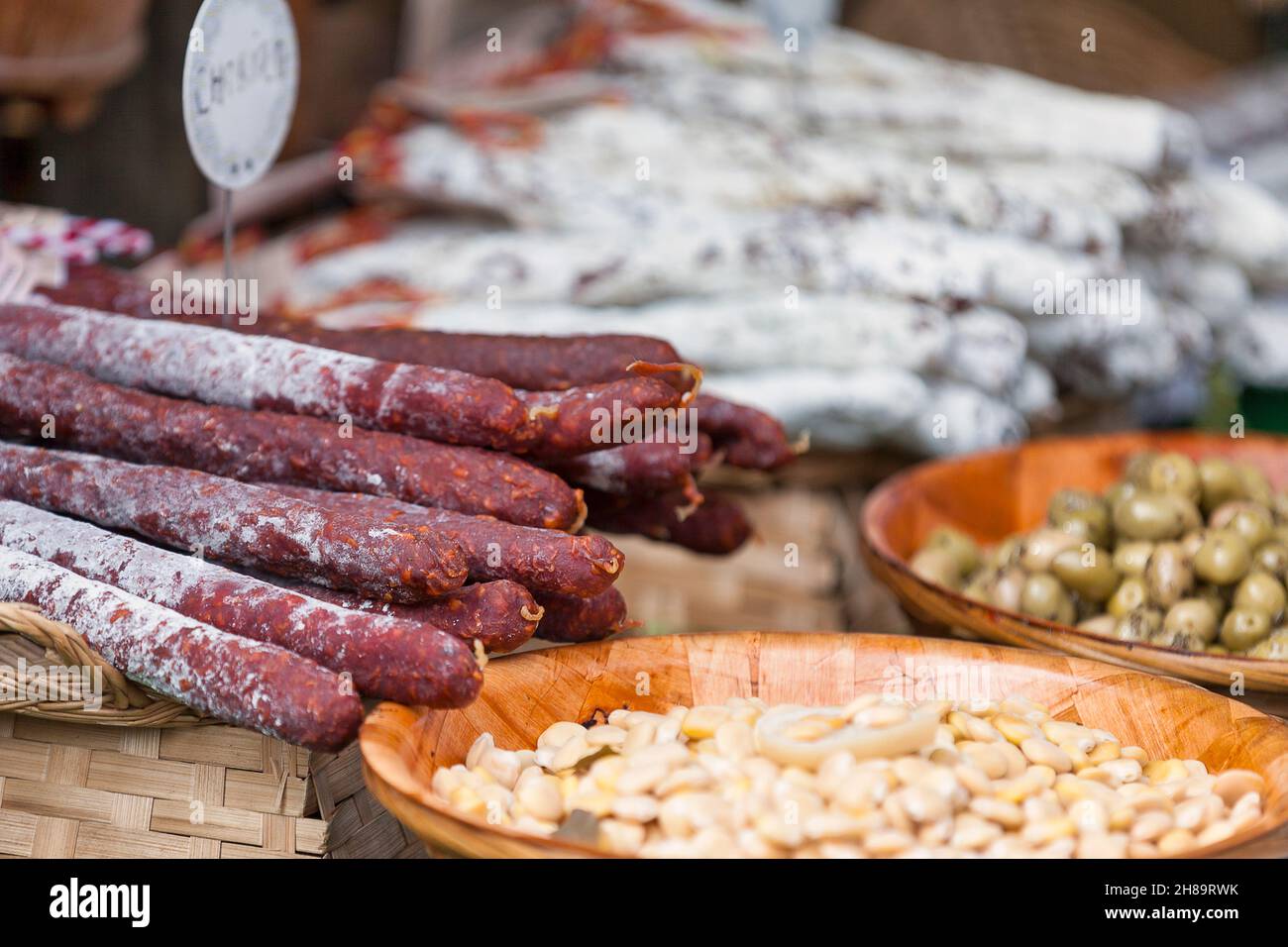 Stack of chorizo sausages and other delicacies for sale on a market stall. Stock Photo