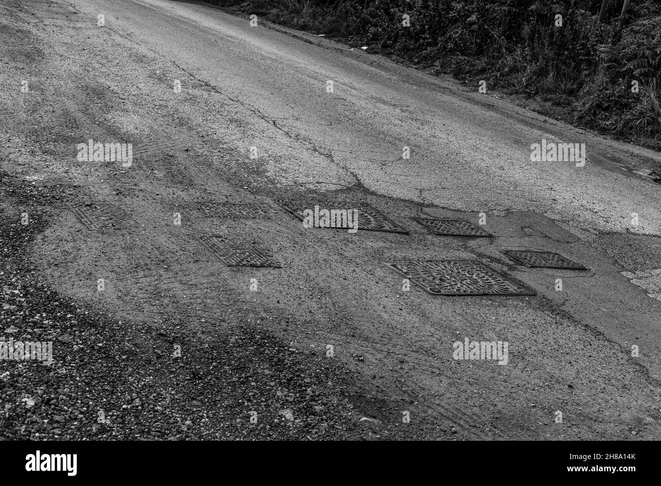 Manhole covers on a unkept road. Stock Photo