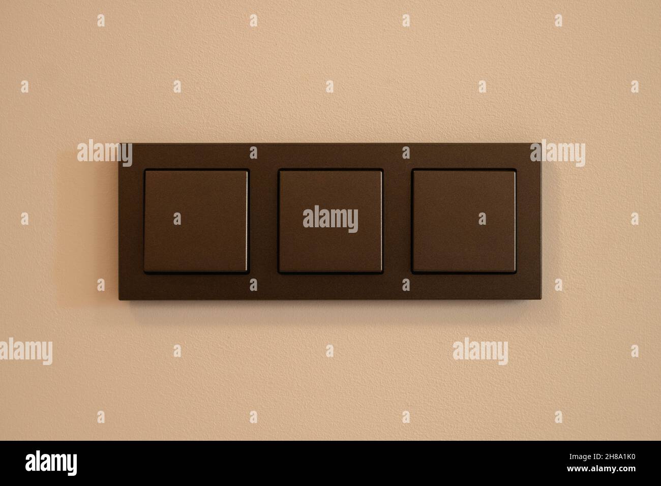 Three position light switch in brown on a white background Stock Photo Alamy